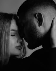 black and white photograph of a man kissing a woman's head with her eyes closed