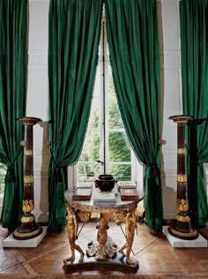 an elegant dining room with green drapes and gold accents