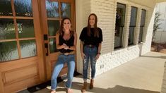 two young women standing next to each other in front of a door