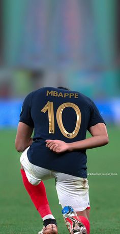 a man kneeling down on top of a soccer field