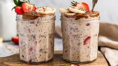 two mason jars filled with overnight oatmeal topped with sliced bananas and strawberries