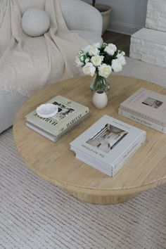 a coffee table with books and flowers on it