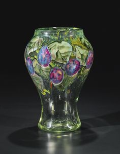 a glass vase that has flowers painted on it's sides and leaves in the middle