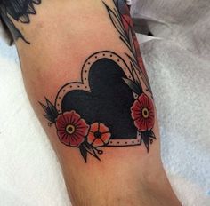 a heart shaped tattoo with flowers on it