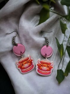 Indulge in a sweet fusion of culinary art and animal whimsy with these Highland Cow macaron acrylic earrings. Designed to resemble delectable macarons with an adorable Highland Cow face, these earrings capture the essence of playful creativity. The soft transparent pink hue and delightful cow character combine for a treat that's as eye-catching as it is charming. Crafted from lightweight acrylic for all-day comfort, they're the perfect accessory for pastry enthusiasts, animal lovers, or anyone with a penchant for unique, conversation-starting jewelry. Quirky Handmade Pink Earrings, Quirky Pink Earrings, Quirky Pink Jewelry Gift, Quirky Pink Jewelry As A Gift, Adjustable Animal Design Earrings As Gift, Animal Design Dangle Earrings As Gift, Highland Cow Face, Cow Character, Culinary Art