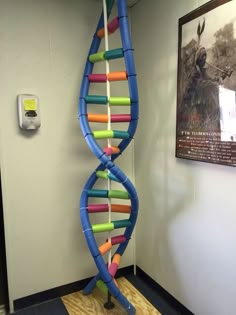 a large blue and yellow spiral shaped object in an office cubicle with pictures on the wall