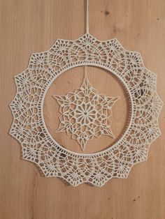 a white doily hanging on a wooden door with a star decoration in the middle