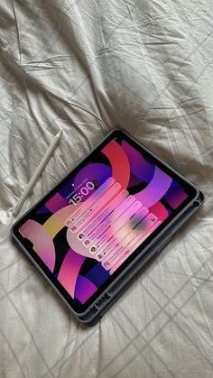 an ipad on a bed with white sheets