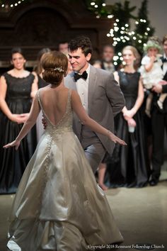 a man and woman dancing together in formal wear