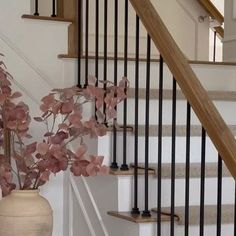 a vase filled with flowers sitting next to a stair case