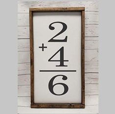 a sign with the number two and six on it in front of a white wall