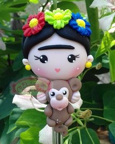 a small figurine with flowers on her head holding a baby doll in its arms