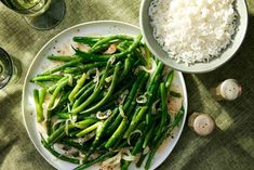 a white plate topped with green beans and rice next to two bowls filled with rice