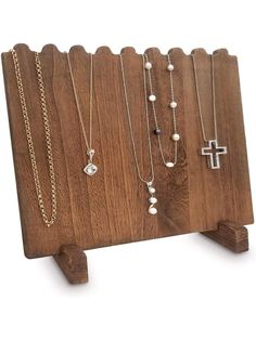 a wooden stand with several necklaces on it and a cross hanging from the top