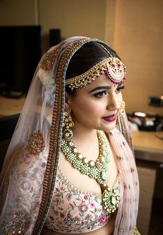 a woman wearing a bridal outfit and jewelry