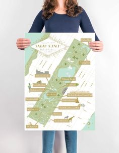 a woman holding up a map with the names of major cities in gold and green