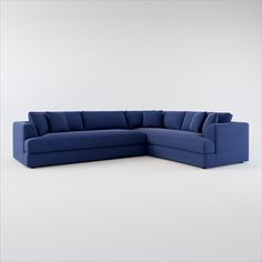 a large blue sectional sofa sitting on top of a white floor next to a wall