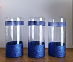 three blue vases sitting on top of a wooden table