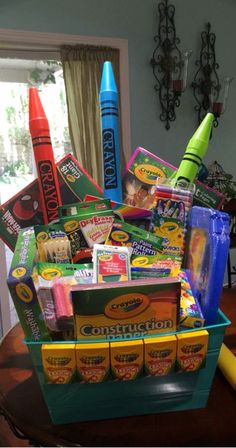 a basket filled with crayons and other items on top of a wooden table