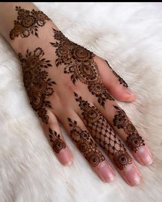 a woman's hand with henna tattoos on it