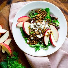 an apple and lentula salad on a white plate