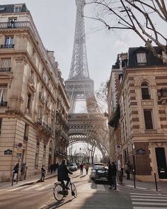 the eiffel tower towering over paris is seen from an empty street in front of some buildings