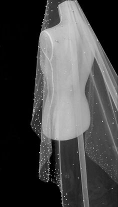 a wedding veil is hanging on a mannequin's torso in black and white