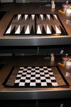 a black and white checkered board sitting on top of a wooden table next to other items