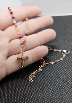 Add a splash of color and spirituality to your accessory collection with our handmade multicolor beaded cross necklace. This unique piece is meticulously crafted with a variety of autumn-toned beads, creating a vibrant and eye-catching design. The delicate cross pendant features a mix of colors (burgundy, yellow, orange, green, purple, coral and white) that perfectly complements the beaded chain, making it a versatile and meaningful accessory. Features: Materials: High-quality beads in autumn to Multicolor Beaded Cross Jewelry, Spiritual Cross Necklace With Lobster Clasp, Spiritual Cross Necklaces For Jewelry Making, Adjustable Cross Necklace With Lobster Clasp, Multicolor Wire Wrapped Crystal Necklace As Gift, Cross Shaped Beaded Chain For Jewelry Making, Cross-shaped Beaded Chain For Jewelry Making, Multicolor Wire Wrapped Necklace For Gift, Cross Shaped Beaded Chain Necklace Gift