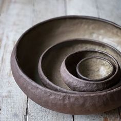 three brown bowls sitting on top of a wooden table