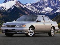 a silver car parked in front of mountains