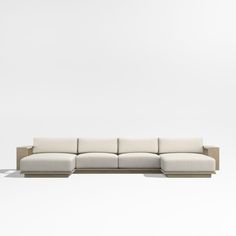 a white couch sitting on top of a wooden floor next to a wall in an empty room