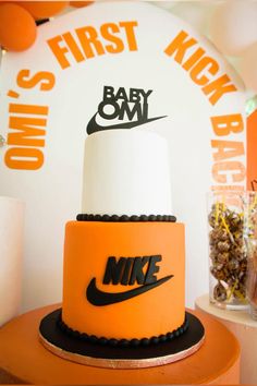 there is a cake that has the nike logo on it and an orange base with white frosting