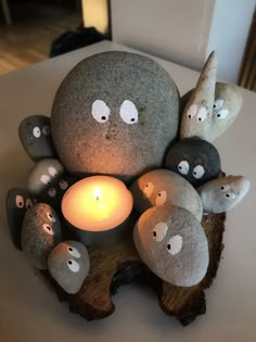 a group of rocks sitting on top of a table next to a lit candle