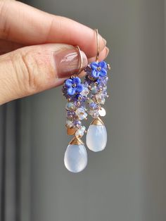 This is a pair of exquisitely blue chalcedony. I used light blue opal and tanzanite to creating a gradient effect, embellishing a lampwork flower. They also weigh very well and are suitable for daily wear. ●Chalcedony ●Opal ●Tanzanite ●Lampwork flowers ●14K gold filled ●total length approximately: 2 inches ●weight：4.1g Welcome to visit my Jewelry store: https://www.etsy.com/shop/Ukuly 🌸The delivery time to Most regions of North America, Australia and Europe is usually about 10-15 days. Buyers from Brazil, South Korea, and Indonesia, please provide me with your tax number through messages or notes for smooth shipment. Thank you. 🌸Please let me know your phone number when you place an order. It will be used for shipping label only. 🌸I will pack the goods very carefully and beautifully. Th Exquisite Gemstone Dangle Earrings, Gemstone Dangle Cluster Earrings As Gift, Exquisite Dangle Earrings With Gemstone Accents, Dangle Earrings With Gemstone Accents For Anniversary, Anniversary Dangle Earrings With Gemstone Accents, Briolette Earrings With Gemstone Accents For Anniversary, Fine Jewelry Dangle Cluster Earrings Gift, Handmade Dangle Cluster Earrings For Anniversary, Handmade Briolette Earrings For Anniversary