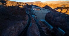 an aerial view of the hoover dam and surrounding mountains at sunset, taken from above