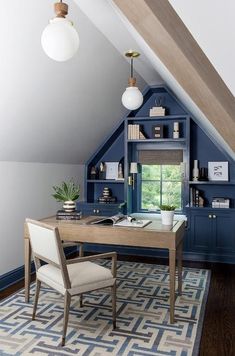 an attic office with blue painted walls and built - in shelving