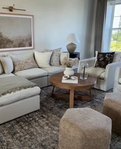 a living room filled with furniture and a large painting hanging on the wall above it