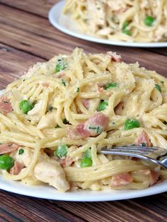 pasta with peas and ham on a white plate, ready to be eaten by someone