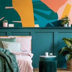 a bedroom painted in teal, pink and yellow with an abstract painting on the wall