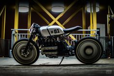 a motorcycle parked in front of a building with yellow beams on it's side