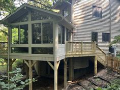 a house that is in the woods next to some trees