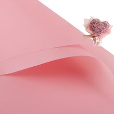 a pink paper with a rose on it and some other things in the corner next to it