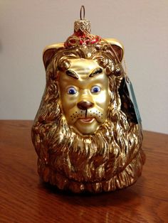 a golden lion head ornament on top of a wooden table