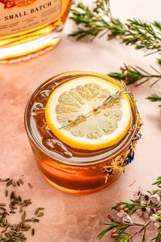 a glass jar filled with honey and lemon sitting on top of a table