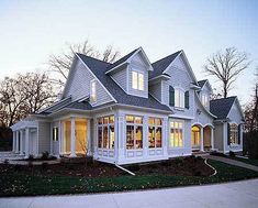 a large white house with lots of windows on the front and side of it's roof