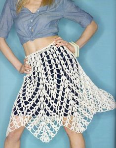 a woman wearing a crochet skirt and crop top with her hands on her hips