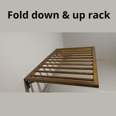 a wooden bed frame with the words fold down and up rack above it in front of a white wall