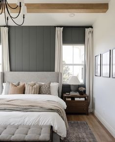 a bedroom with gray walls and white bedding