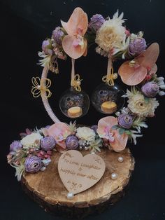 an arrangement of flowers and cupcakes on a tree stump